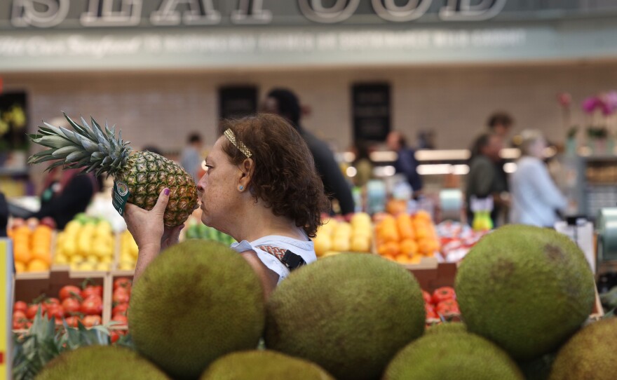 Karen Dahl of Greece smells a pineapple during the opening of the Whole Foods in Brighton on Wednesday, April 12, 2023. "I'm just so excited for an alternative to Wegmans," Dahl said.