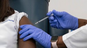 A nurse is inoculated with the COVID-19 vaccine. (Mark Lennihan/AFP via Getty Images)