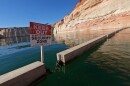 A sign reading "keep out" is displayed just upstream of Glen Canyon Dam at Lake Powell, June 8, 2022, in Page, Ariz.