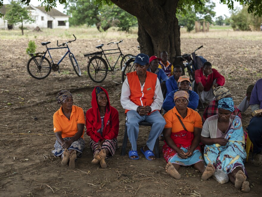 Farmers in the town of Mondiane meet to discuss sustainable farming practices in November. Members of the local disaster preparedness committee wear orange vests with the acronym for the national disaster preparedness agency.