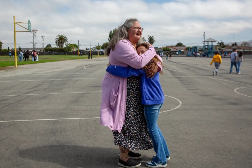 Catalina Cisneros, secretary at Loma Vista Elementary School, gets a hug from a student on the first day of school in Salinas on Aug. 8, 2023.