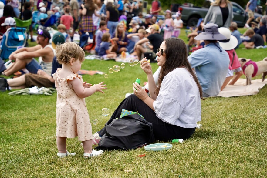 A picture of a mother and daughter playing with bubbles at KPCW's Back Alley Bash August 2025