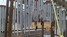 Dozens of wind chimes hang from wooden beams strapped to the bed of a truck.