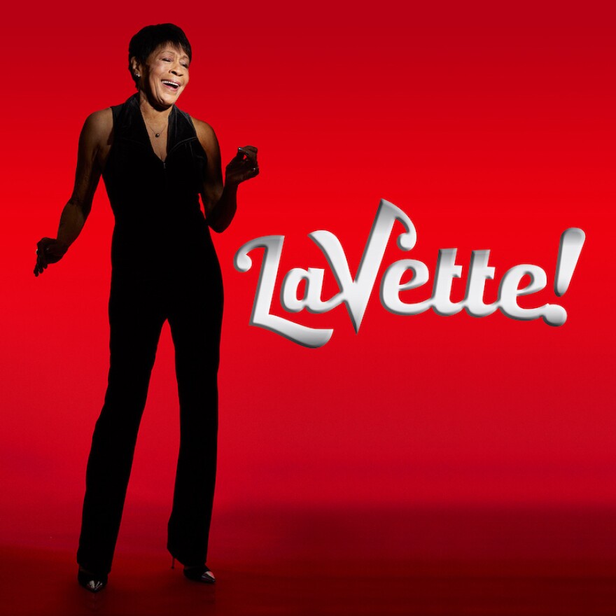  Bettye LaVette standing in front of a red background with the word "LaVette!" next to her.