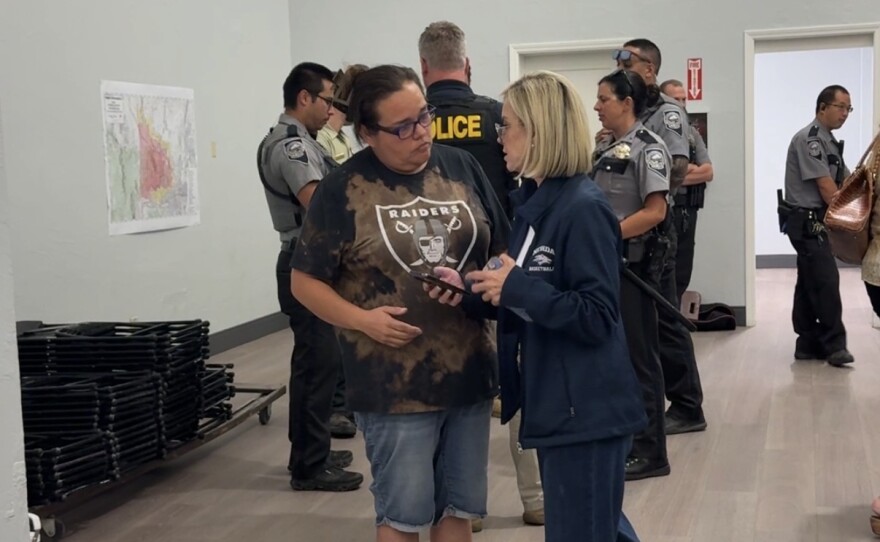 Two women are speaking to each other while standing.