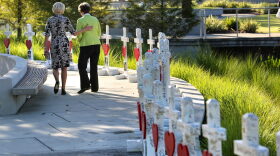 Orlando city commissioner Patty Sheehan (right) and a friend take a last look at crosses in July honoring the 49 victims of the Orlando Pulse shooting. A judge said today that the city of Orlando must release audio recordings of the gunman talking to police dispatchers and negotiators. (File/AP)