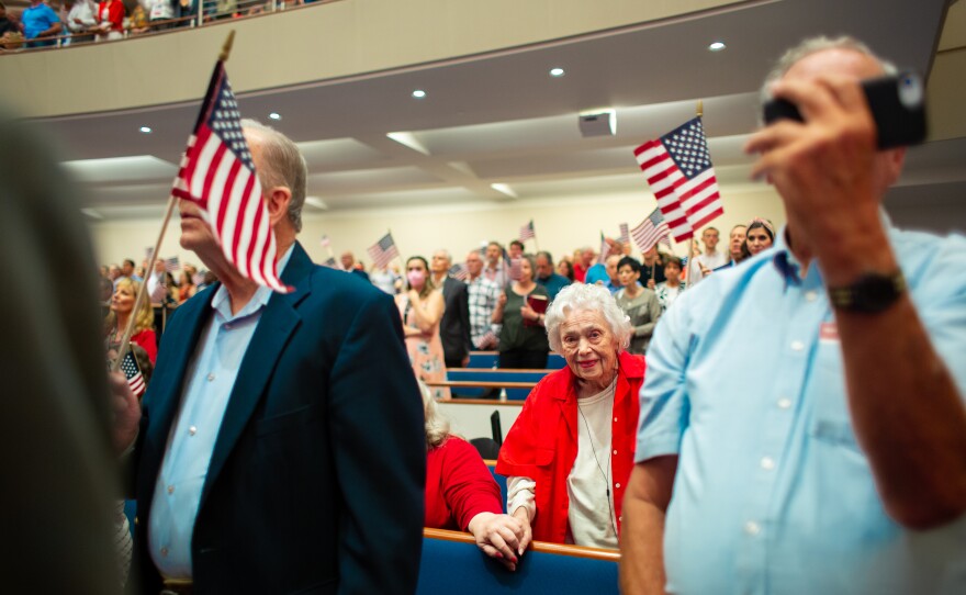 Churchgoers wave American flags as performer Lee Greenwood sings “Proud to be an American” at First Baptist Dallas.