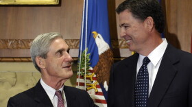 In this Sept. 4, 2013, file photo, then-incoming FBI Director James Comey talks with outgoing FBI Director Robert Mueller before Comey was officially sworn in at the Justice Department in Washington. (Susan Walsh/AP)