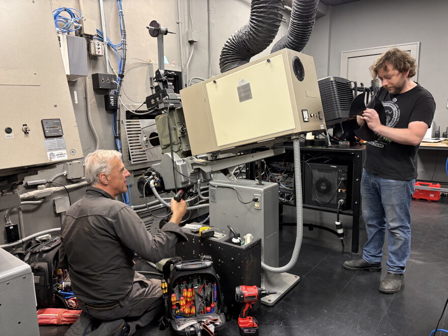 Milwaukee Film technical director Kevin Rice (right) and renowned Chicago-based projectionist James Bond work on installing brand new shutters for the projector that were manufactured specifically for the Oriental Theater's projectors.