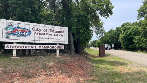 An Edmond police car sits behind the entrance for the Arcadia Lake campground.