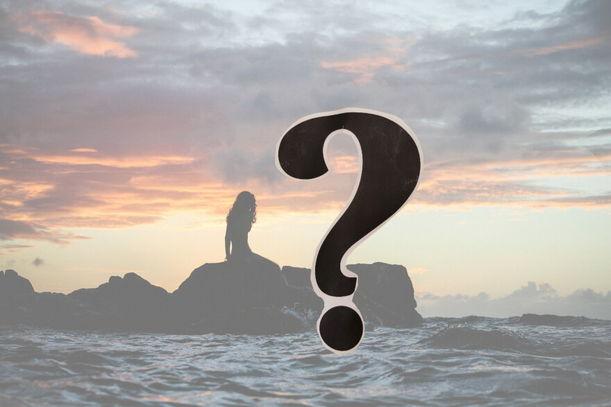 Silhouette of a woman on a line of rocks in the ocean at sunset; a question mark in the foreground 
