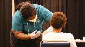 A vaccinator administers a dose of a COVID-19 vaccine at the Ernest N. Morial Convention Center. March 4, 2021.