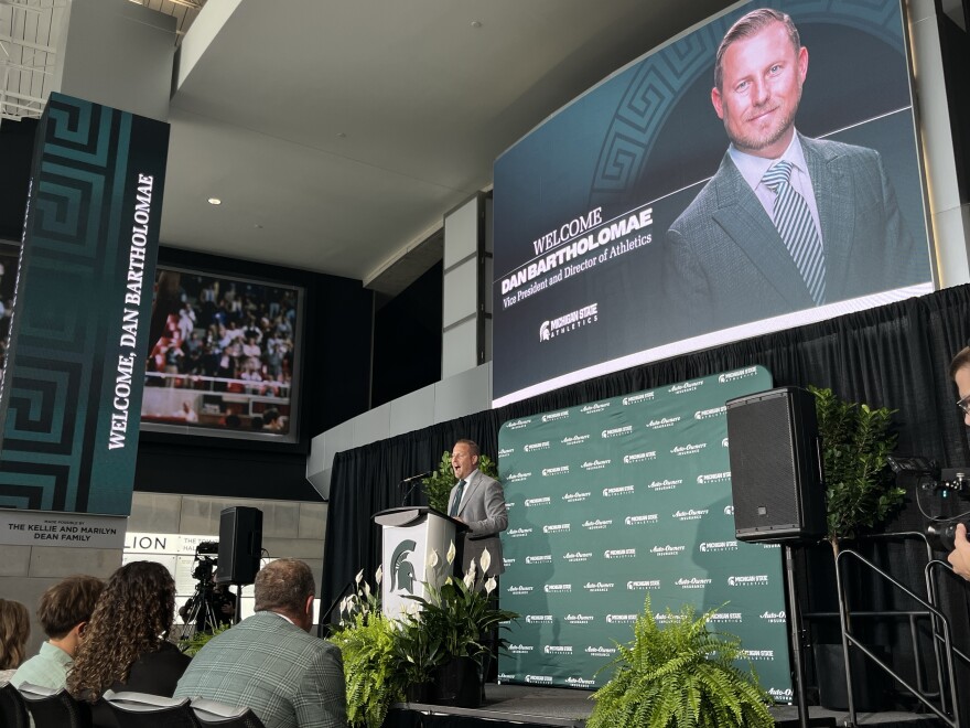 A man speaks into a microphone at a podium