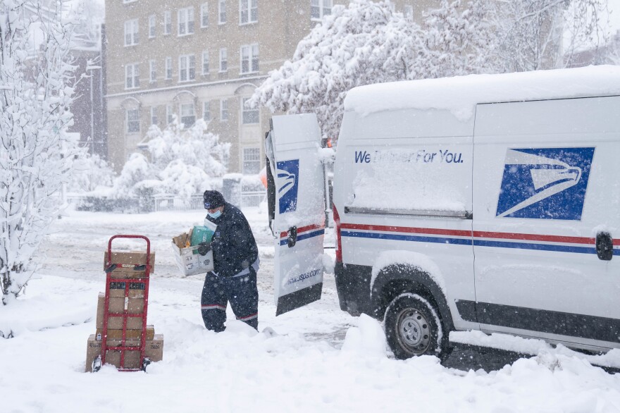 A postal worker carries packages through the snow on Jan. 3 in Washington, D.C.