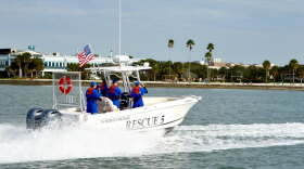 People in blue wet suits on boat 