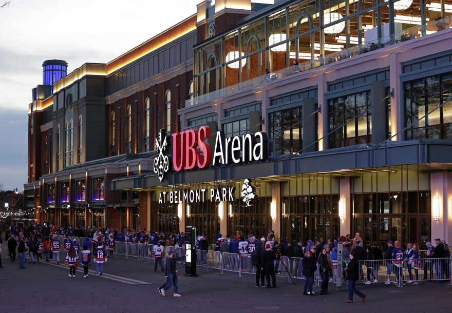 FILE - Fans wait to enter the new UBS Arena for the first New York Islanders NHL hockey game against the Calgary Flames, on Nov. 20, 2021, in Elmont, N.Y. (AP Photo/Adam Hunger, File)