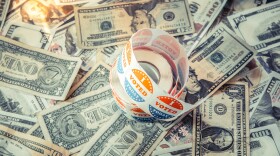A photo of a reel of 'I voted today' stickers on top of various American dollar bills. 