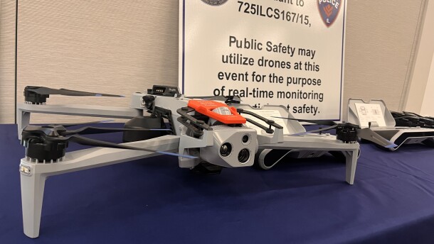 A grey drone sits on a blue table