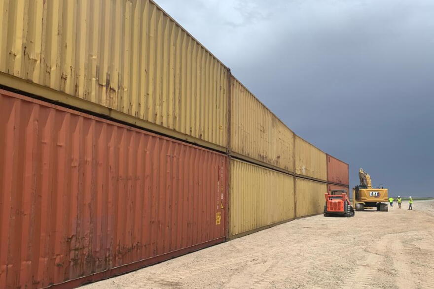 This photo provided by the Arizona Governor's Office shows shipping containers that will be used to fill a 1,000 foot gap in the border wall with Mexico near Yuma, Ariz., on Aug. 12, 2022. The Cocopah Indian Tribe said Friday, Sept. 2, that the state of Arizona acted against its wishes by stacking shipping containers on its land to prevent illegal border crossings.