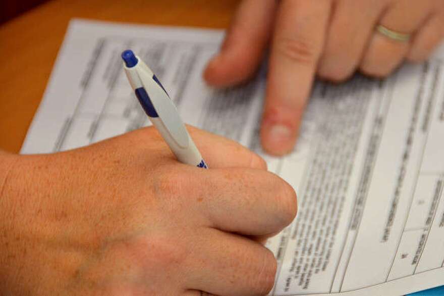 Hands signing a form