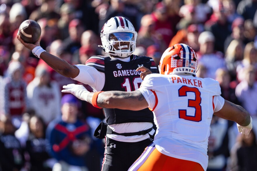 FILE - South Carolina quarterback Lanorris Sellers (16) throws under pressure from Clemson defensive end T.J. Parker (3) during the first half of an NCAA college football game, Nov. 29, 2025, in Columbia, S.C. (AP Photo/Scott Kinser, File)