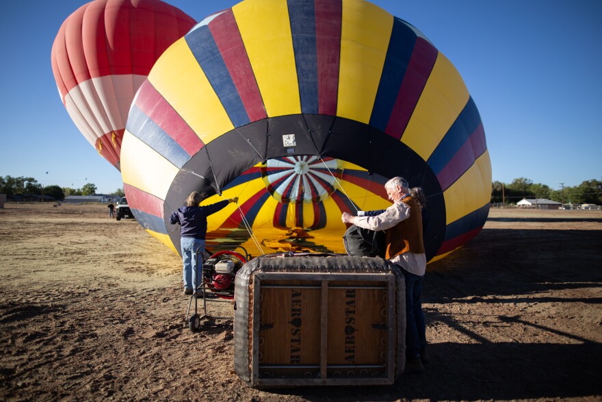 Pilot Gary Michalek checks on-board equipment while a noisy fan inflates his balloon