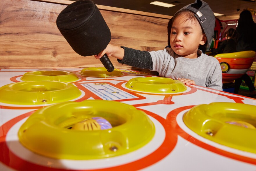 Mica Advento whacks Minions at Chuck E. Cheese.