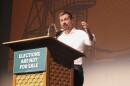 Former Transportation Secretary Pete Buttigieg speaks at a podium inside Butte’s Mother Lode Theater. A sign on the podium reads, “Elections Are Not For Sale.”