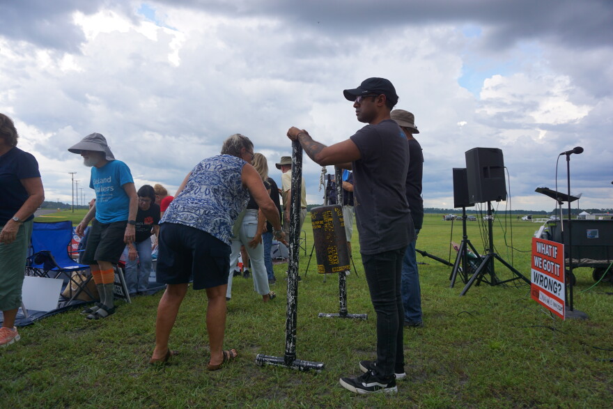 Protestors sound a gong with anti-death penalty stickers on it while chanting “not in my name” in protest of the execution. (Alexa Ryan/WUFT News)