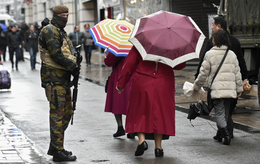 A soldier patrols outside a Brussels shopping center Saturday, after the government put the city on its highest terror alert. All metro train stations in the city are now closed.