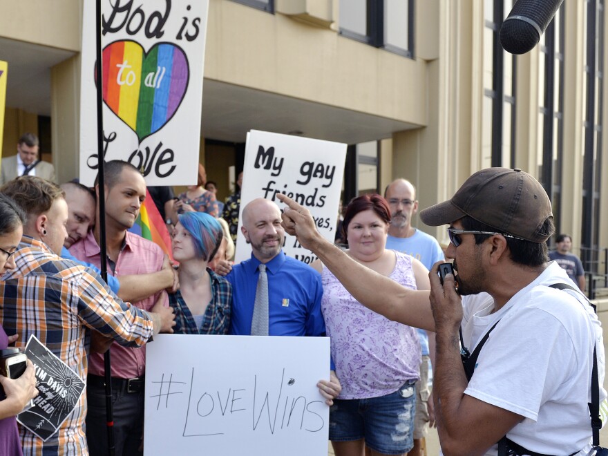 Edgar Orea, right, preaches to a group of same sex marriage supporters that gathered outside the Carl D. Perkins Federal Building in Ashland, Ky., on Thursday. Supporters of jailed County Clerk Kim Davis plan a prayer rally to call for her release.