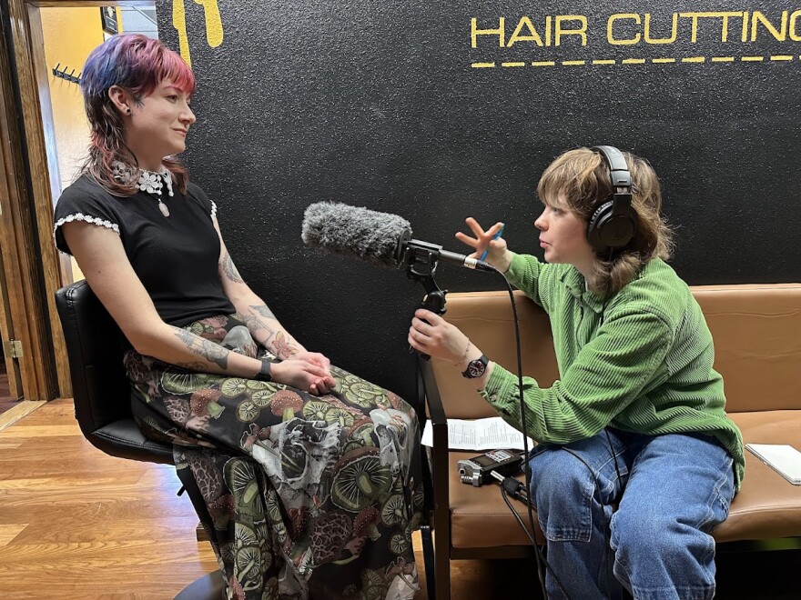 Reporter interviewing stylist at salon.