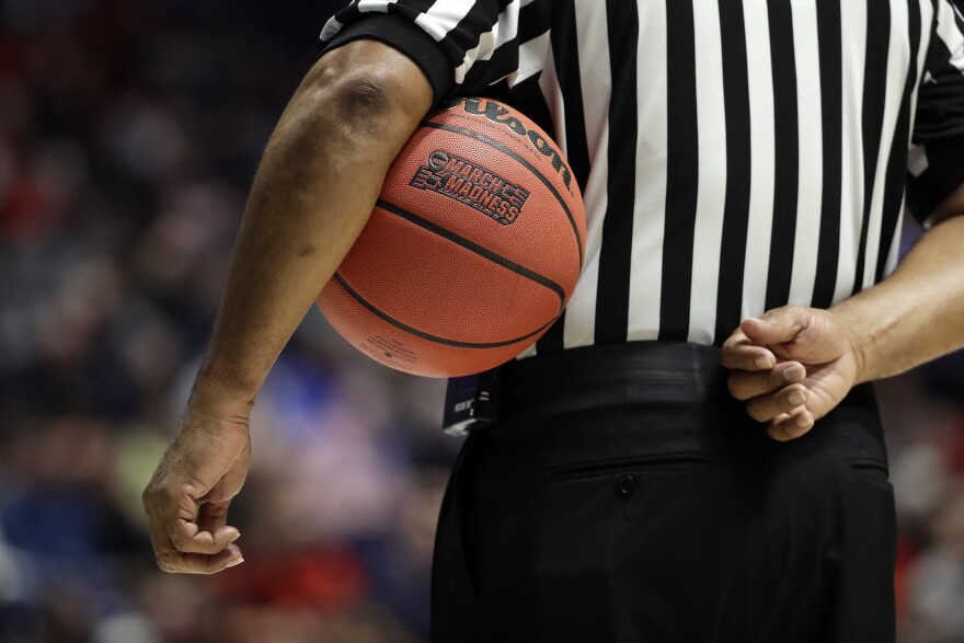 An NCAA referee waits for play to resume during a game between Cincinnati and Nevada in the 2018 NCAA college basketball tournament.