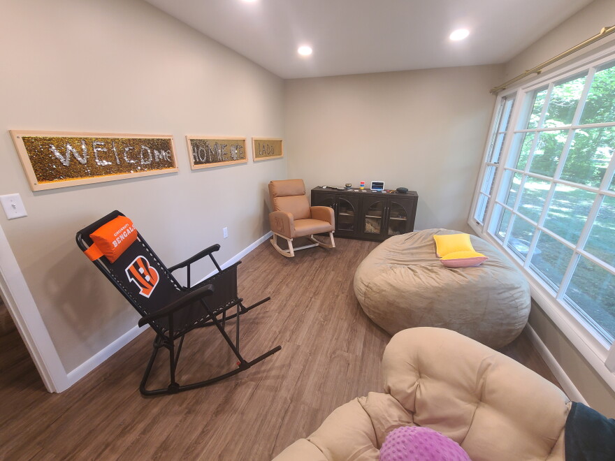 room with soft chairs and windows looking onto a back yard