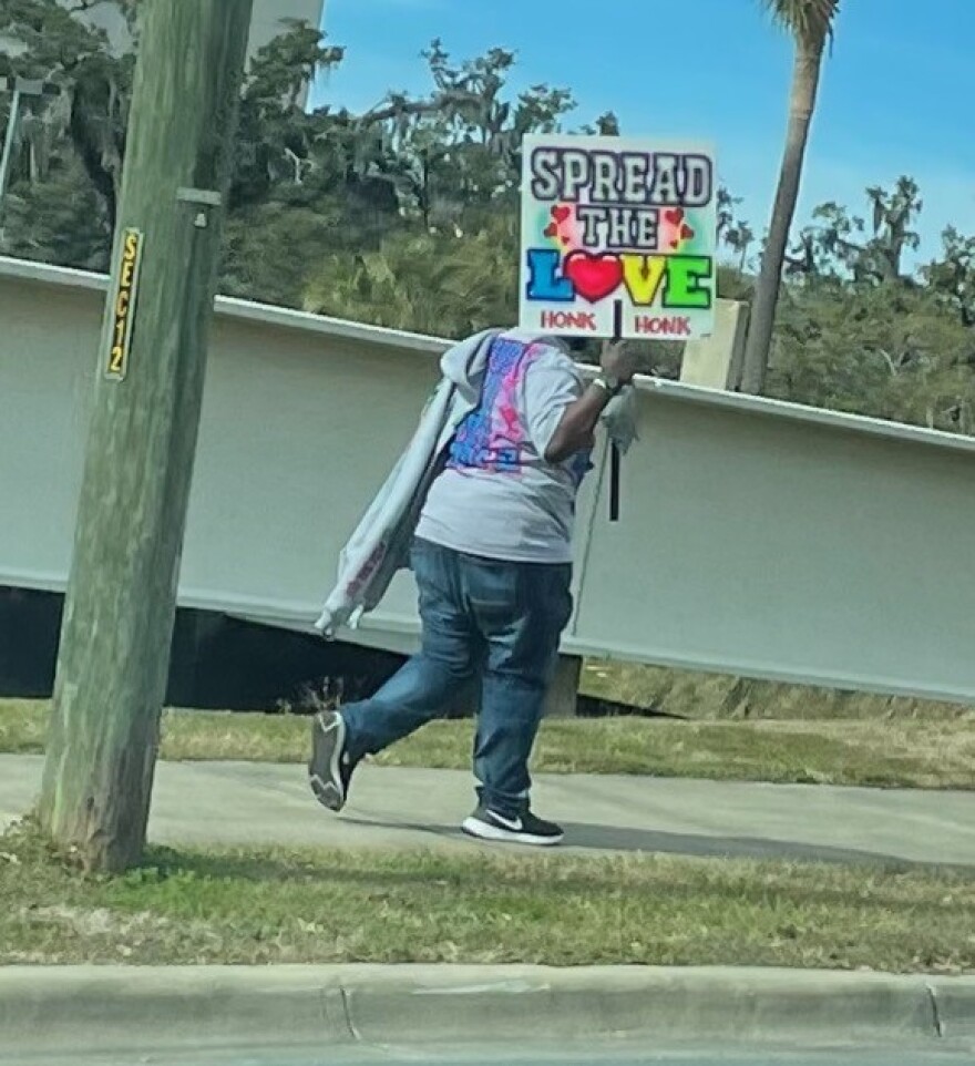 Decarius Hunter of Panama City carries his "Spread the Love" sign to the capitol