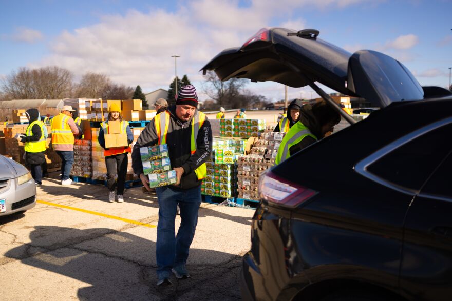 Food Bank volunteers load cars with groceries at mobile food pop-up distribution.