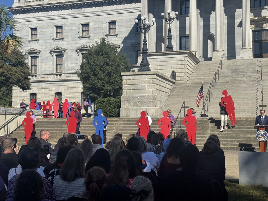 Volunteers hold silhouettes representing victims of domestic violence on the south steps of the Statehouse during the 2026 Silent Witness Ceremony in Columbia.