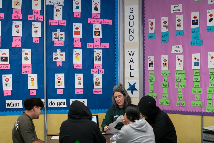 Teacher Katy Reese, center, works with students in a literacy class at Oakland International High School in Oakland on March 7, 2025.