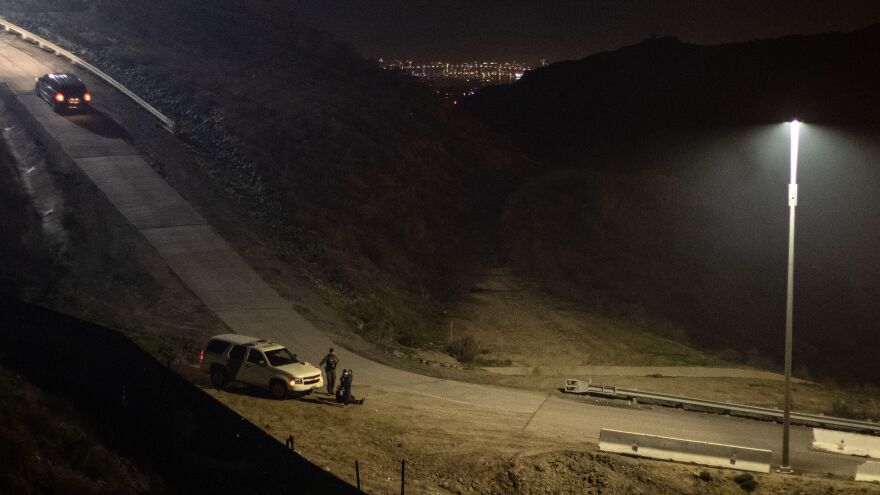 A Border Patrol agent arrests a group of Central American migrants after crossing the U.S.-Mexico border fence from Tijuana to San Diego County late last year.