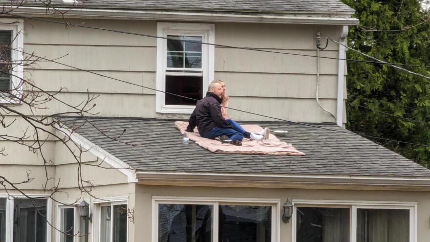 Brighton residents find a rooftop perch to watch the eclipse.