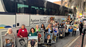 Parents hold pictures of their children with autism, as they prepare to advocate for them in the state legislature.