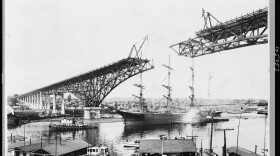 The tall ship Monogahela passes under the uncompleted Aurora Bridge circa 1931.