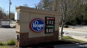 A brown and tan Kroger fuel sign displays gas prices beside a roadway in Athens.