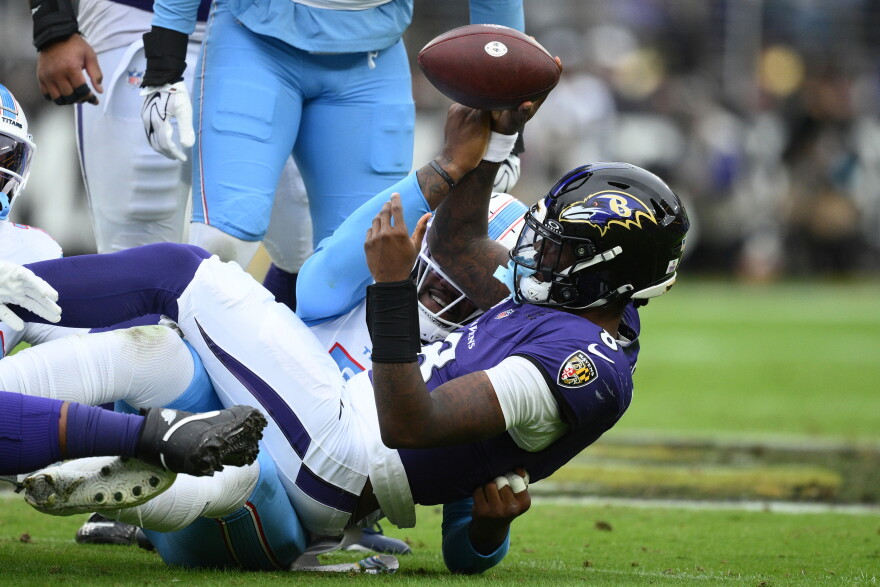 Baltimore Ravens quarterback Lamar Jackson (8) is sacked by Tennessee Titans defensive end Jacob Martin, left, during the first half of an NFL football game in Baltimore, Sunday, Oct. 4, 2026. (AP Photo/Nick Wass)