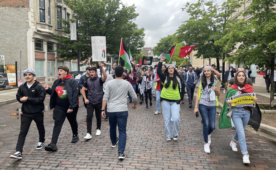 Protestors marched down a cobblestone street in downtown Dayton, in protest of Israeli violence against Palestinians. Protestors were wearing Kaffiyehs and waving Palestinian flags, as they chanted "free, free Palestine."