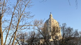 The Missouri State capitol building's dome is visible through tree branches, no or minimal leaves because it's winter. 