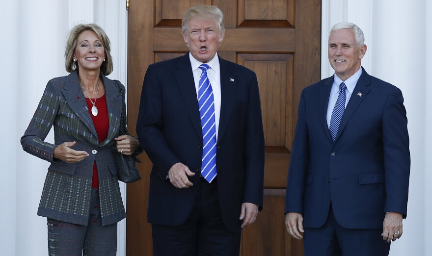 President-elect Donald Trump calls out to media as he Vice President-elect Mike Pence and Betsy DeVos pose for photographs at Trump National Golf Club Bedminster clubhouse in Bedminster, N.J., Saturday, Nov. 19, 2016.