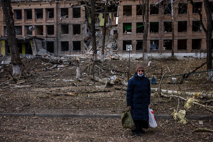 A woman stands in front of a destroyed building after a Russian missile attack in the town of Vasylkiv, near Kyiv, on  Sunday. Russian forces faced stiff resistance over the weekend and faced logistics problems in their invasion plans.