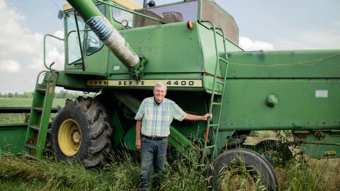 Dennis Kellogg proudly stands next to his John Deere combine from the 1970s. He said he'll use this equipment to harvest his crop later this year. 