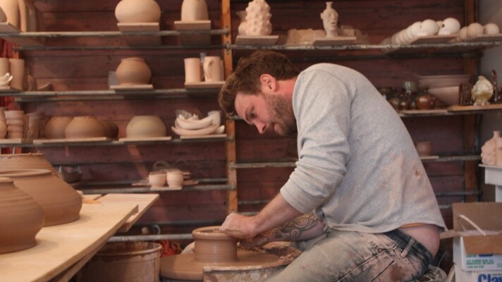 Artist Cyrus Swann works at the pottery wheel in 2014.